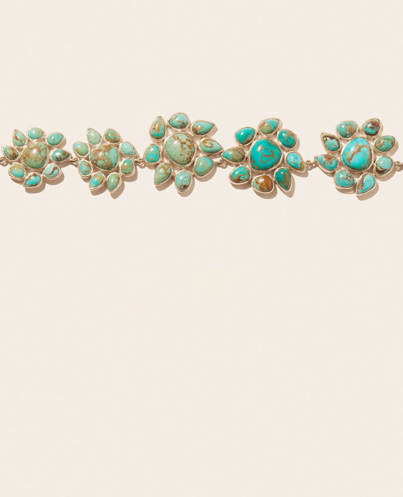 The Necklace GLORIA N°2 by Pascale Monvoisin features four floral-shaped, Silver 925 brooches with shades of blue and green turquoise. Each is outlined in silver and arranged in a linear fashion, embodying Pascale Monvoisins signature style.