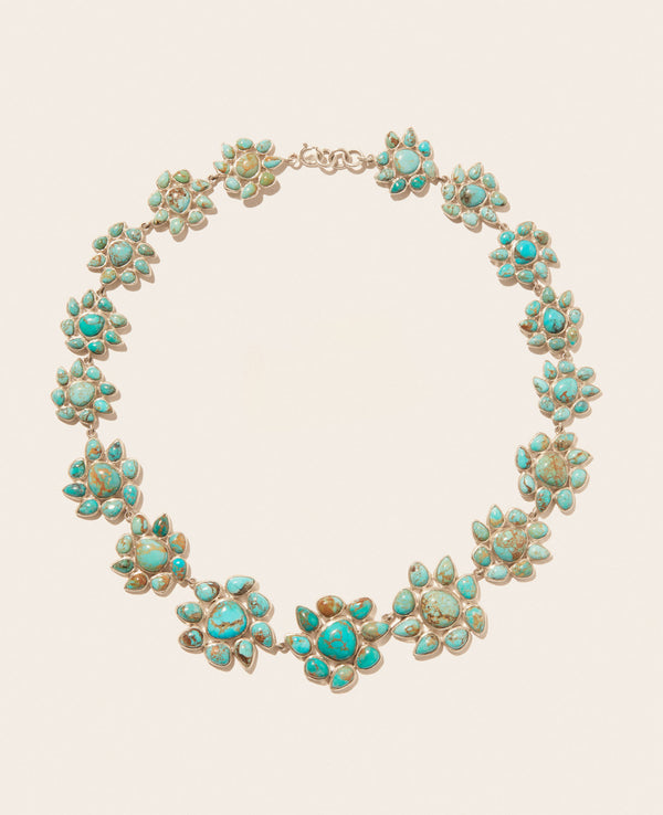 The Necklace GLORIA N°2 by Pascale Monvoisin features flower-shaped clusters set in Silver 925, symmetrically arranged on the chain. It showcases vibrant blue and green hues with intricate detailing against a plain background.