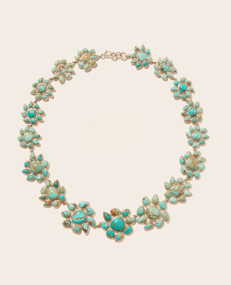 The Necklace GLORIA N°2 by Pascale Monvoisin features flower-shaped clusters set in Silver 925, symmetrically arranged on the chain. It showcases vibrant blue and green hues with intricate detailing against a plain background.