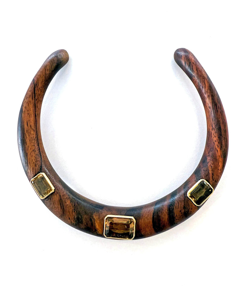 The Jen Proudman Wood and Citrine Collar features chunky dark wood with three rectangular citrine gemstones accented in 14k gold, beautifully displayed on a white background.