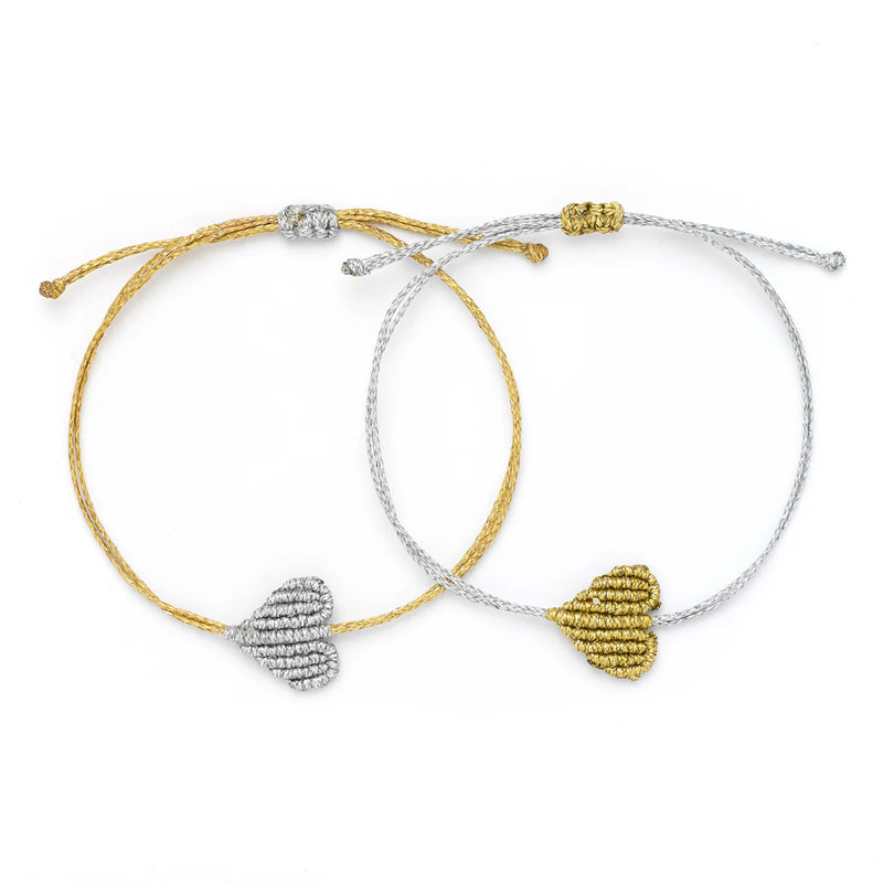 Oiya’s Metallic Heart Bracelets (Copy), shown side by side on a white background, each feature a dainty heart charm—one gold with a silver charm, one silver with a gold charm—and come with an adjustable cord for the perfect fit.