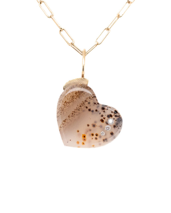 The Karen Luvaas Montana Agate Heart is a gold chain necklace with a heart-shaped pendant featuring a translucent stone with natural brown and orange patterns, accented by three sparkling gems.