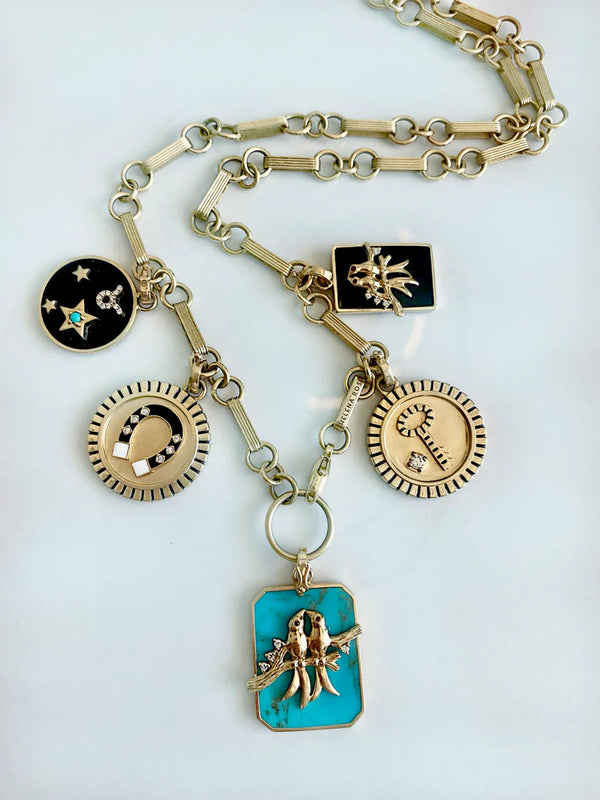The Helena Rose Small Onyx Zodiac Necklace features 14k gold and five unique pendants—black onyx with gold stars, moon, sunburst, sun, and turquoise with a gold hand—perfect for zodiac sign lovers.