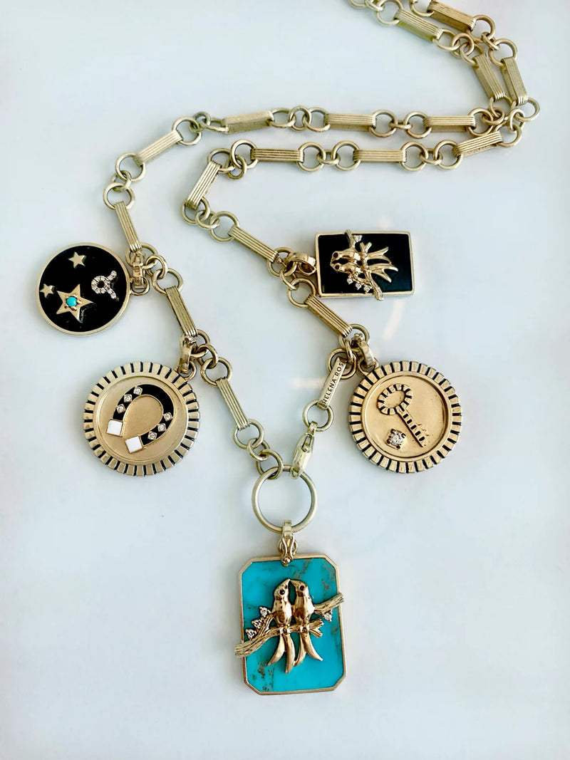 The Helena Rose Small Onyx Zodiac Necklace features 14k gold and five unique pendants—black onyx with gold stars, moon, sunburst, sun, and turquoise with a gold hand—perfect for zodiac sign lovers.