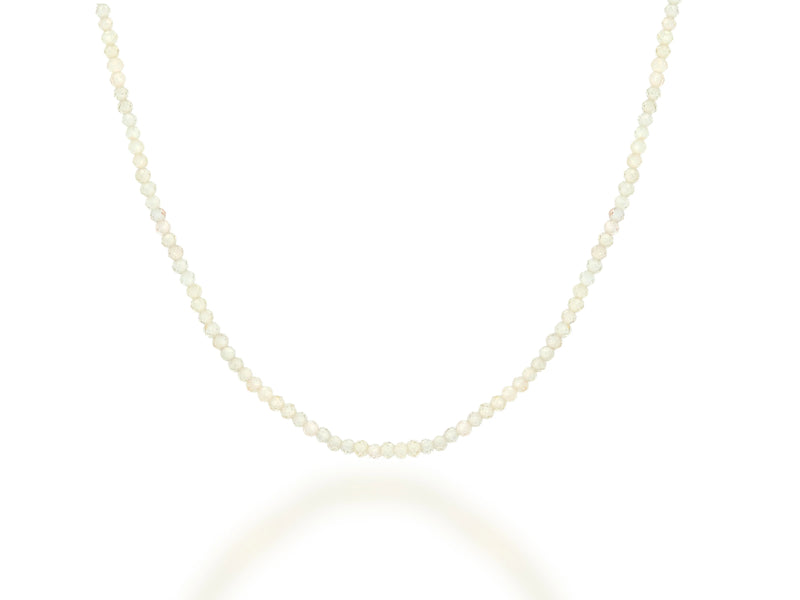 The Rachel Reid 28 Gemstone Bead Necklace features small, round, off-white pearls in a single strand with a 14K yellow gold lobster claw clasp, displayed on a plain white background.