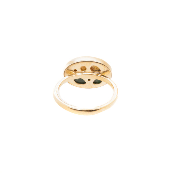 The Karen Luvaas Yin Yang Elliptical Ring, shown from the bottom on a white background, features an oval-shaped setting with small openings and dark green accents inside.