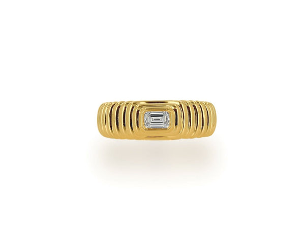 Rachel Reid's exquisite Fluted Emerald Diamond Ring is crafted in 14K yellow gold and showcases elegant fluted horizontal ridges, adorned with a central emerald-cut diamond set against a plain white background.